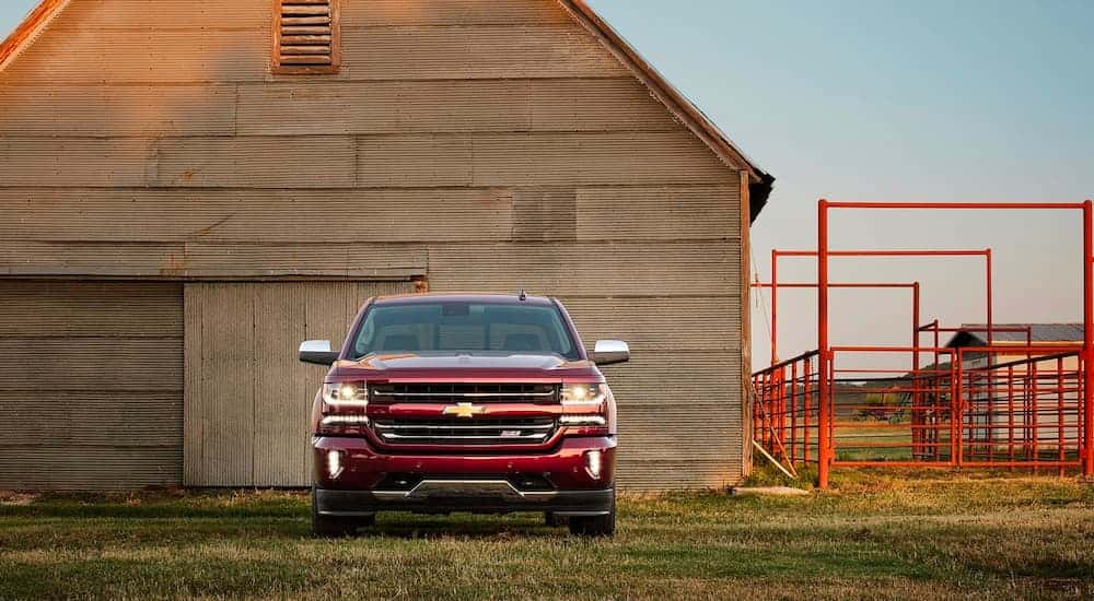 Red 2016 Chevy Silverado 1500 Z71 parked in front of a barn.
