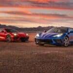 Two 2020 Chevy Corvette C8 parked side by side in front of a sunset.