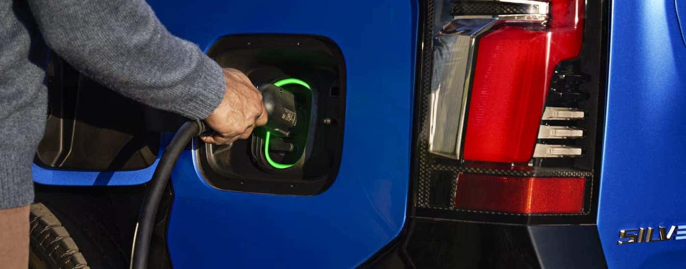 A man plugging in a 2025 Chevy Silverado EV to charge