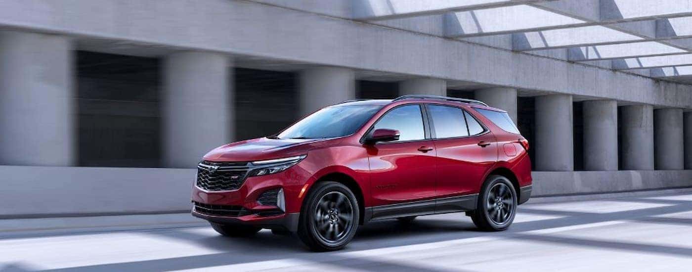 A red 2022 Chevy Equinox RS driving in a city