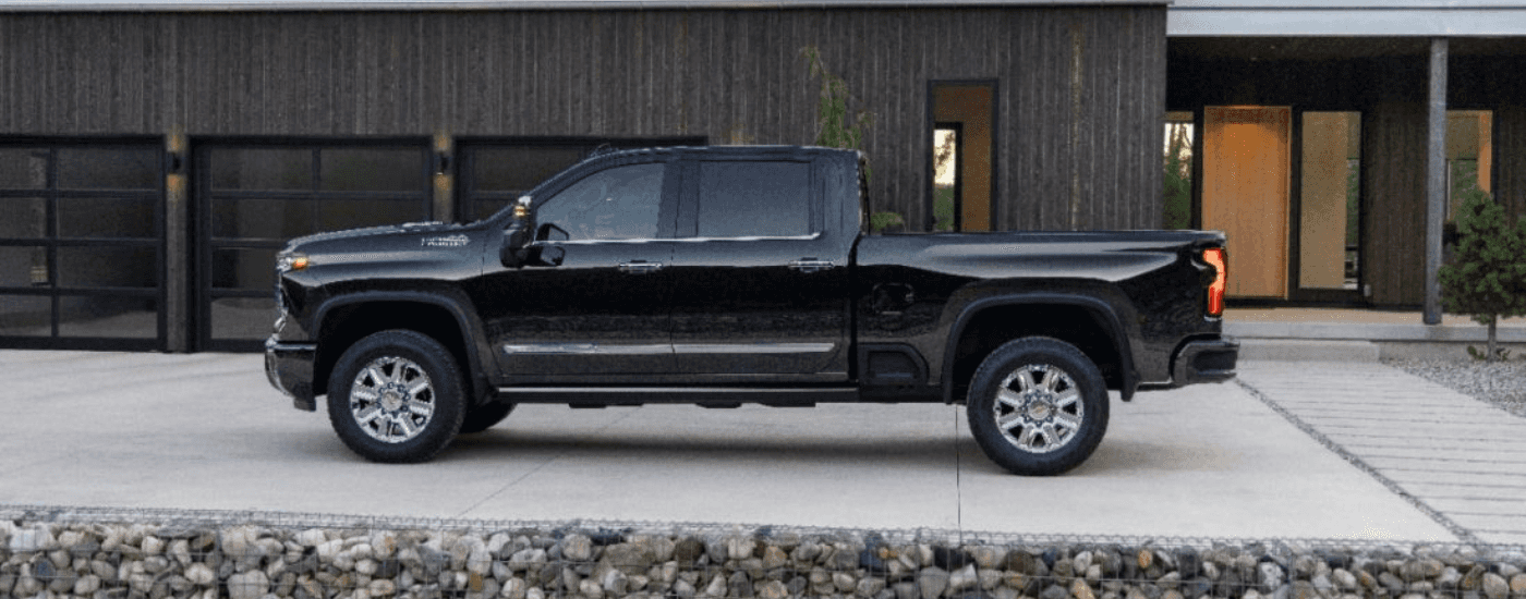 Black 2024 Chevy Silverado 2500 HD High Country in front of a house