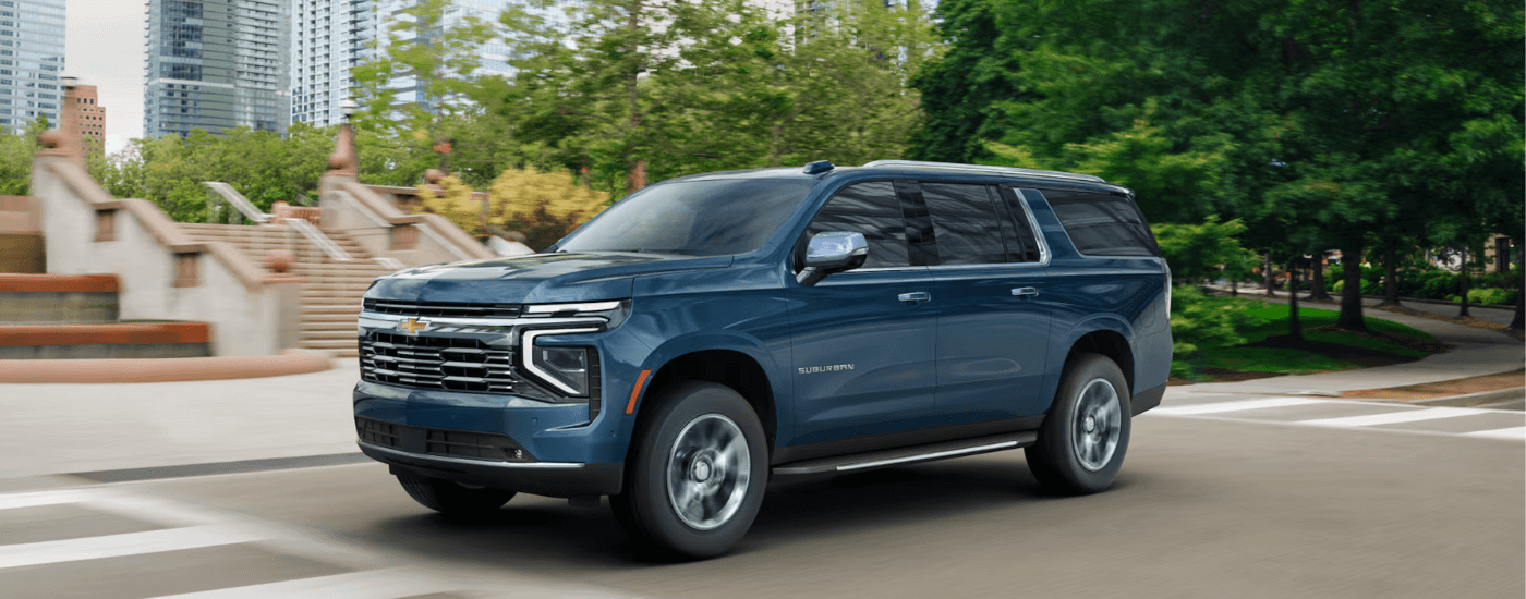 Blue 2025 Chevy Suburban driving through a city