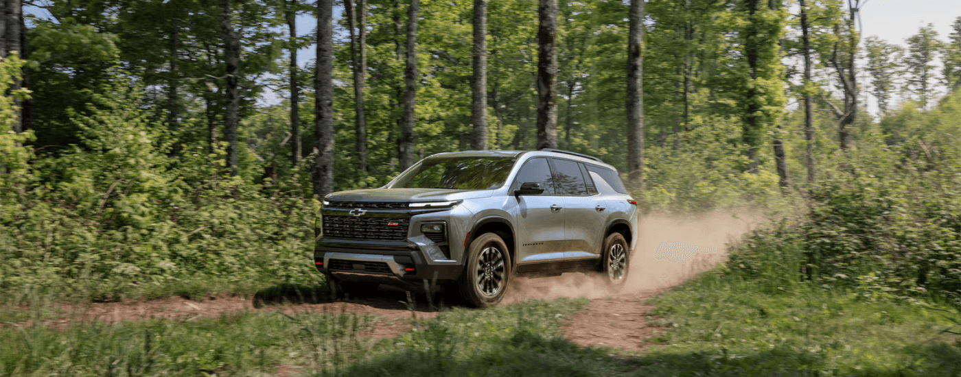 Silver 2026 Chevy Traverse RS driving down a trail