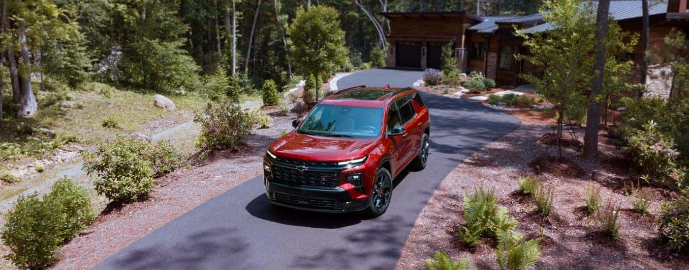 Red 2025 Chevy Traverse RS leaving a home