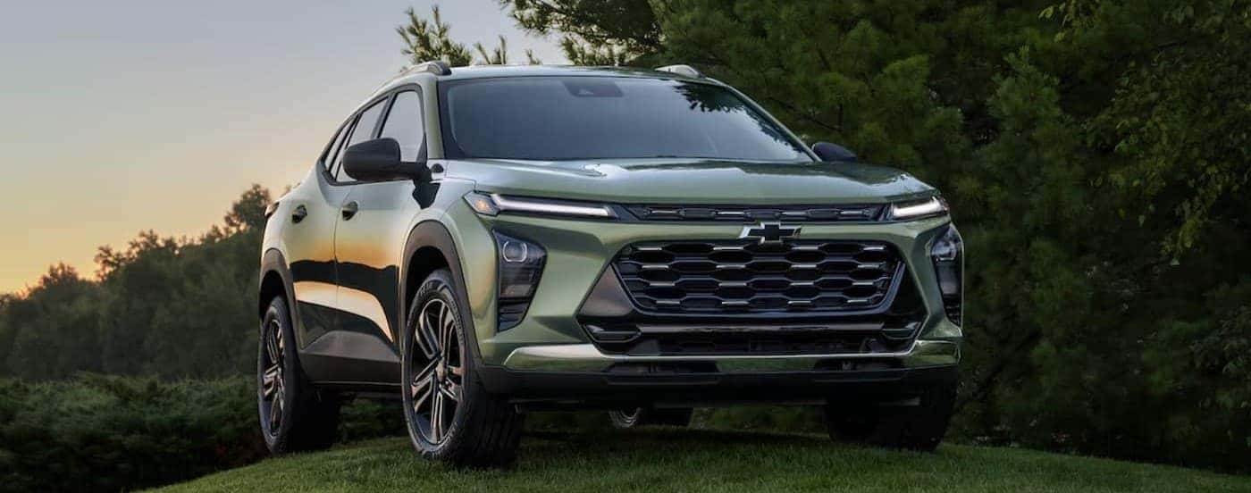 A green 2025 Chevy Trax is parked on grass.