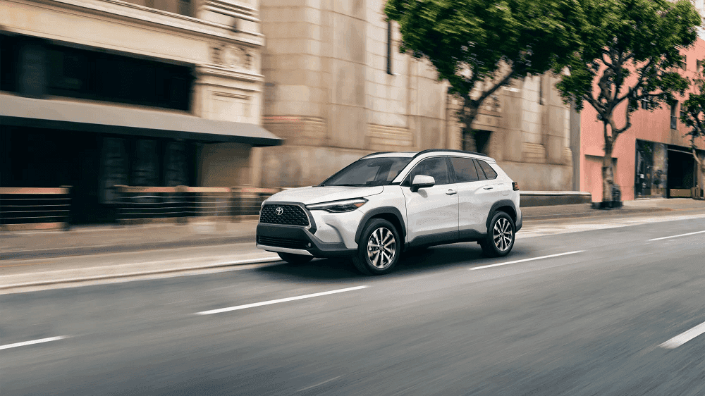 White 2022 Toyota Corolla Cross driving on city street