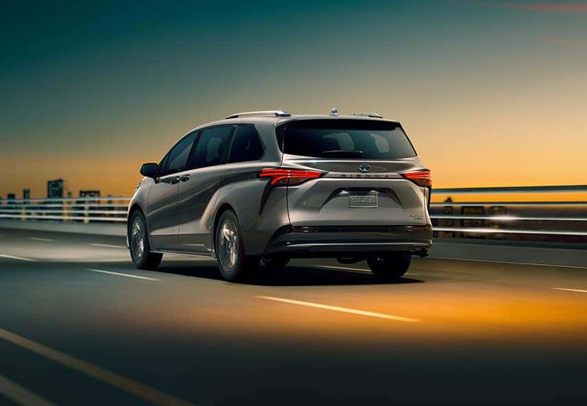 Toyota Hybrid for Everyone at Penn Toyota | Rearview of Silver Toyota Sienna Hybrid Driving on Highway Bridge at Sunset