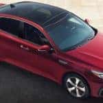 A red 2019 Kia Optima, popular among Kia models, is shown from above on a driveway in Freehold, NJ.