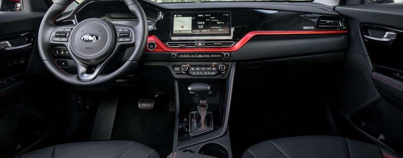 The black and red dashboard in the interior of a 2020 Kia Niro is shown.