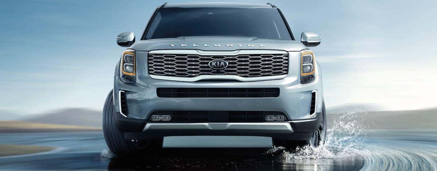 A silver 2021 Kia Telluride is shown from the front driving on a wet road after winning the 2021 Kia Telluride vs 2021 Honda Pilot comparison.