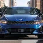 A blue 2021 Kia K5 is parked at a crosswalk after leaving the Kia Dealership in Lakewood NJ.