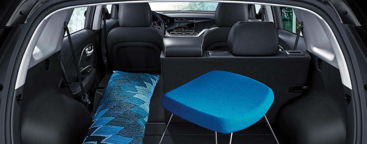 A close up shows the black interior and blue furniture loaded in the trunk of a 2021 Kia Niro EV.