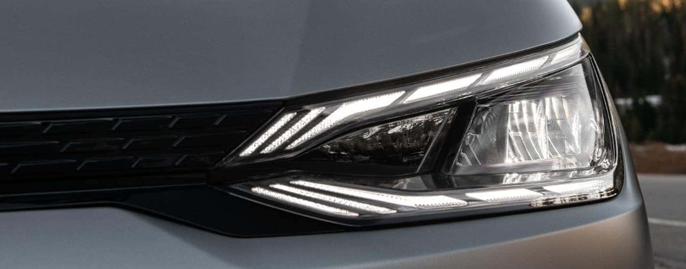 A close up shows the driver side headlight on a silver 2022 Kia EV6.
