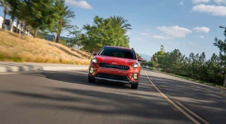 A red 2022 Kia Niro EV is shown from the front after leaving an EV dealer near you.