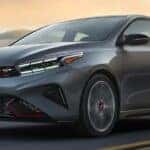 One of the most popular Kia Forte for sale near Marlboro, NJ, a silver 2023 Kia Forte GT, is shown driving on a highway.