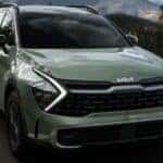 A green 2023 Kia Sportage is shown from the front at an angle.