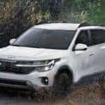 A white 2024 Kia Seltos is shown from the front after leaving a dealer that has Kia SUVs for sale.