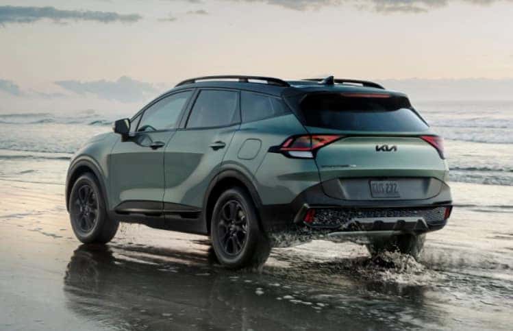 2025 Kia Sportage driving on the beach near the water