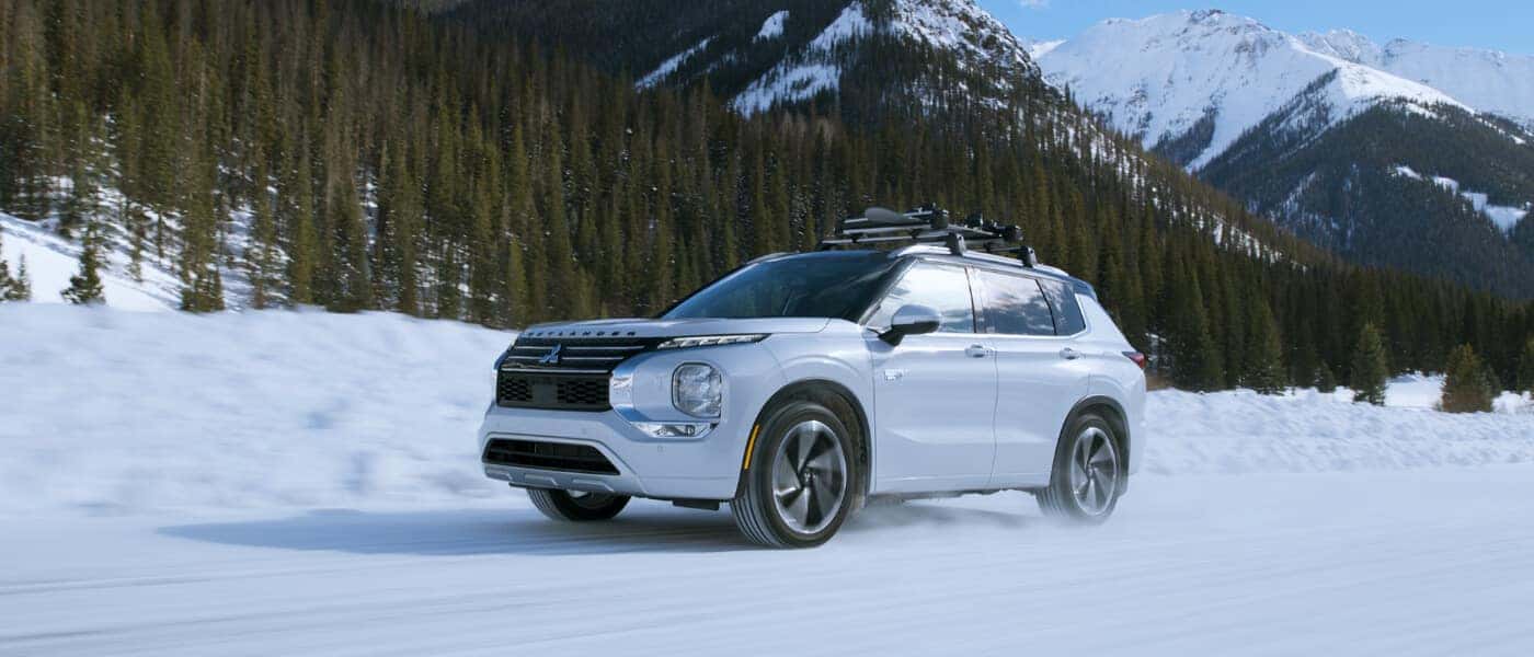 2025 Mitsubishi Outlander PHEV Exterior Driving In Snow Side View