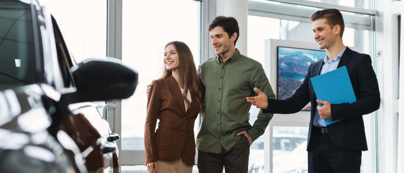 Couple Looking at Car With Sales Rep
