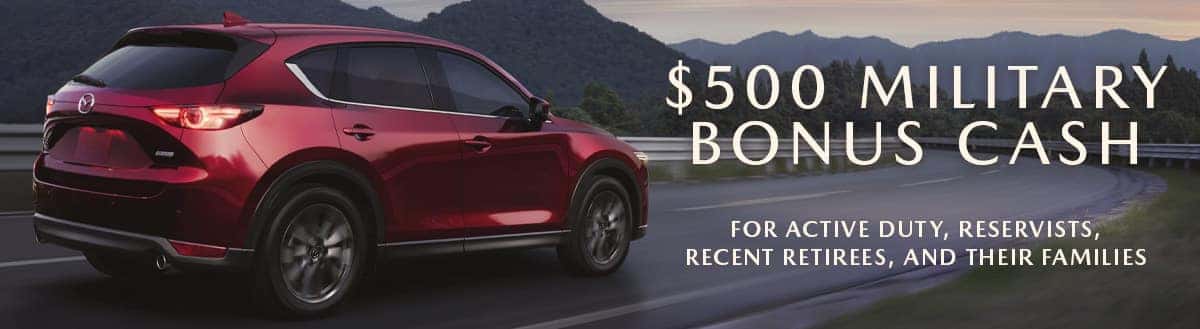Red Mazda CX-5 on the left is driving into the sunset. The words '$500 Military Bonus Cash' and 'For active duty, reservists, recent retirees, and their families' appears on the right. Sport Mazda Orlando, FL