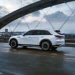 white 2026 maxda cx-90 phev driving across a bridge