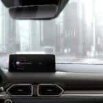 interior of a mazda car looking out windshield with mazda homelink garage door opener on rearview mirror