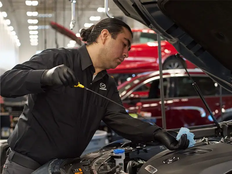 Certified Mazda technician servicing a 2026 Mazda CX-5 at the Sport Mazda South service center in Orlando, Florida