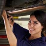 Female Mechanic Working Under Car