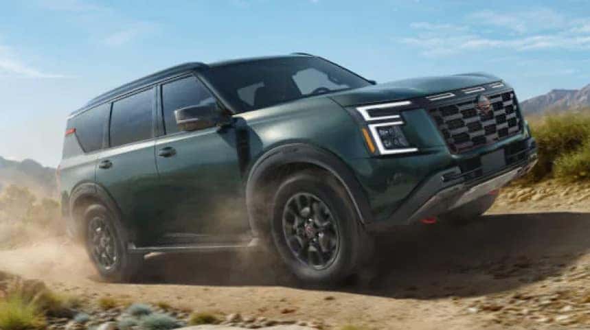 Green Nissan SUV going off-terrain