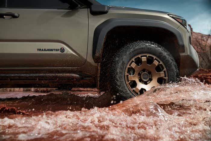 Toyota Tacoma Trailhunter wheel and body detail in off-road terrain