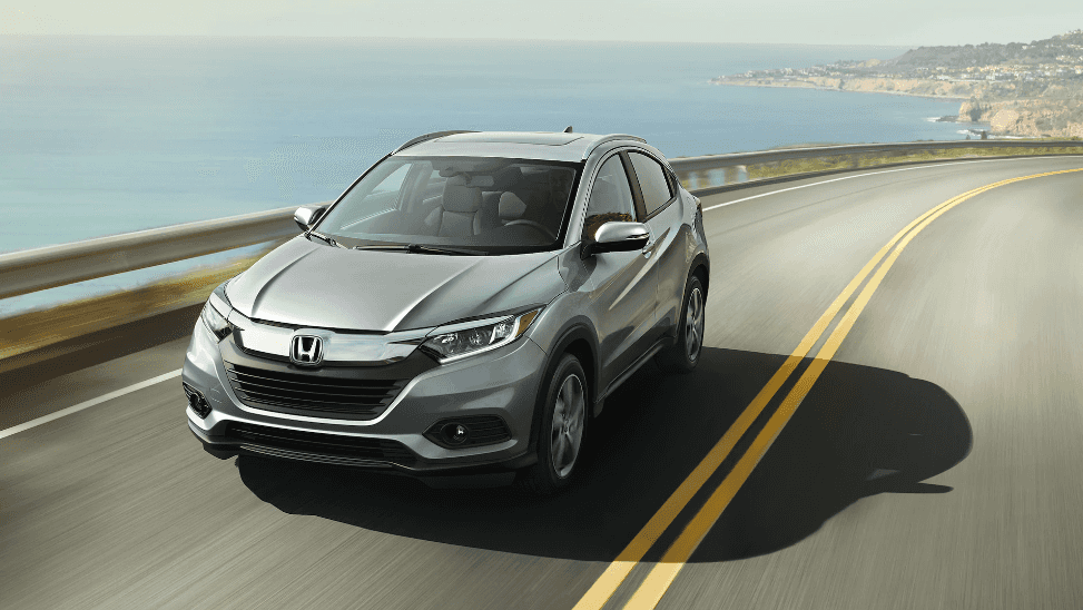 Gray 2024 Honda HR-V driving on highway with body of water in background