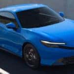 A blue Honda Prelude driving down the highway.