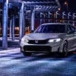 A silver Honda Civic Hybrid parked at night.