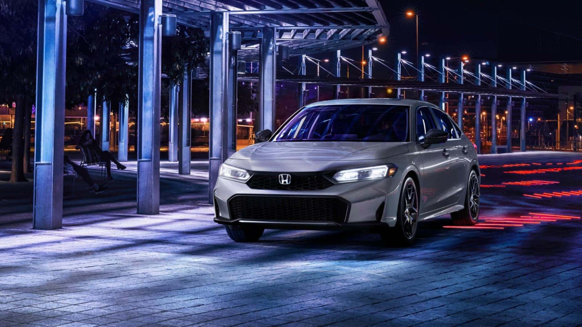 A silver Honda Civic Hybrid parked at night.