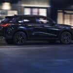 A blue Honda HR-V driving at night through a city.