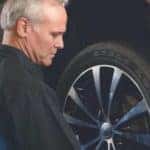 service tech checks car tire