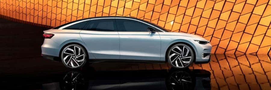 a silver VW ID Aero in front of illuminated orange panels