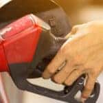 Pumping gas at gas pump. Closeup of man pumping gasoline fuel in