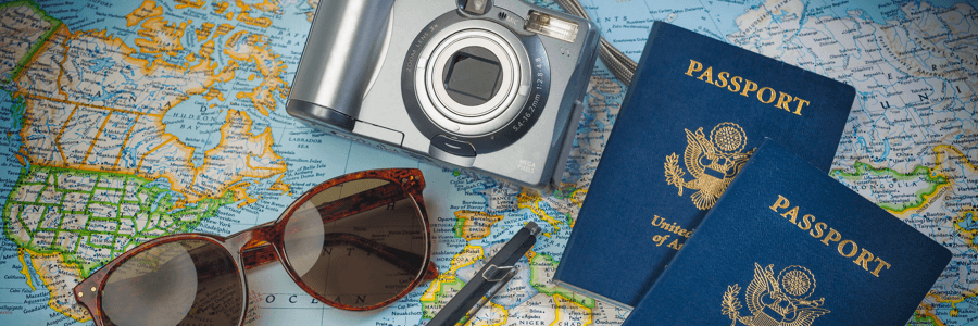 a camera. passport, and sunglasses laying on map a camera. passport, and sunglasses laying on map