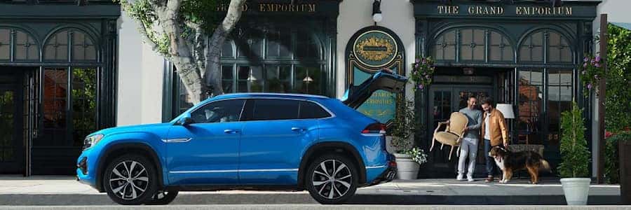couple with a dog putting a chair in the back of their vw atlas cross sport