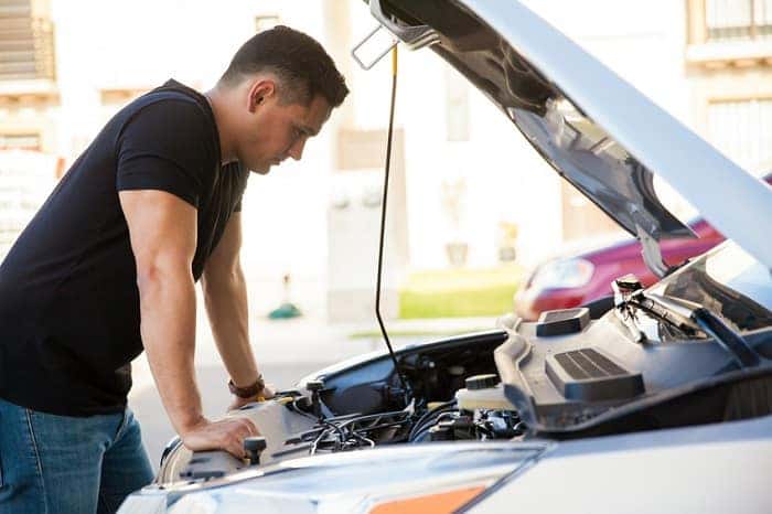 Man looking under hood at Volvo service needs