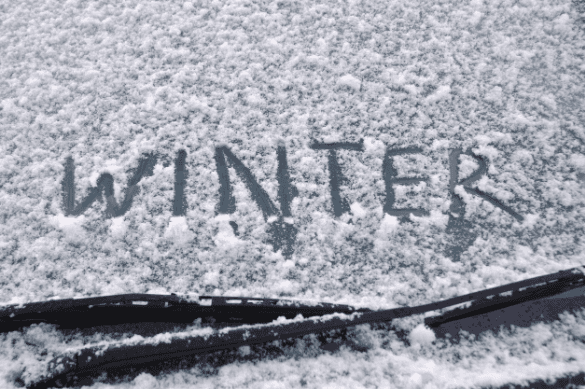 Car windshield covered in snow.