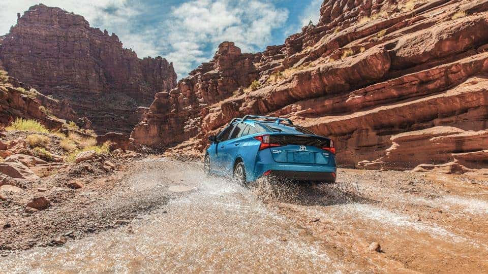 A blue 2020 Toyota Prius driving through a canyon. 