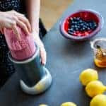 Close up of a person making a smoothie using a bldender at home in kitchen