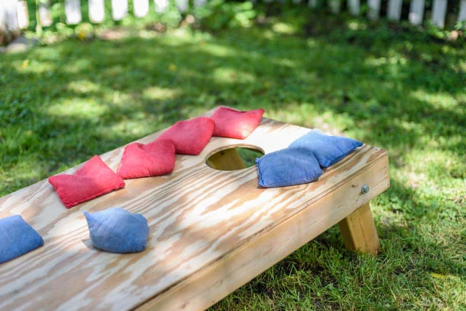 red and blue bags on hommade wood cornhole board