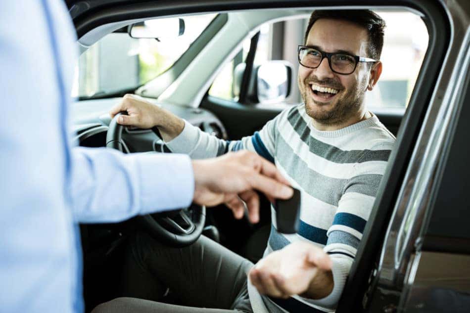 Happy man receiving keys to test drive a vehicle 