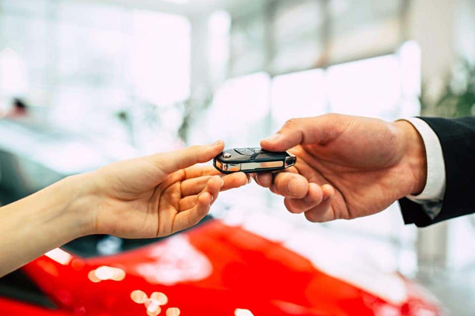 Handing of car keys. The car seller passes the keys to the dealership.