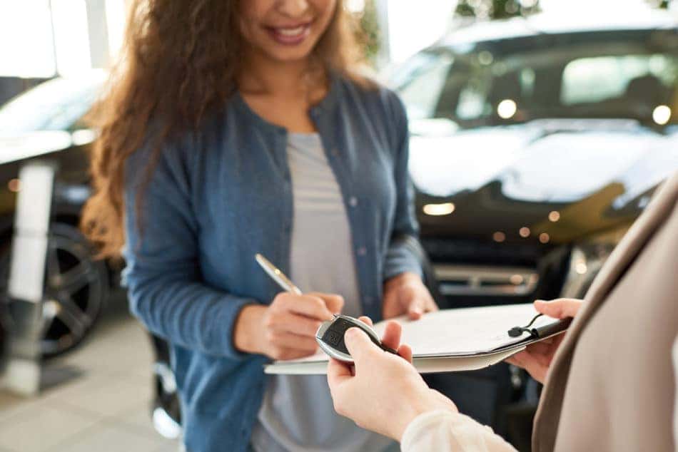 Woman signing contract at dealership