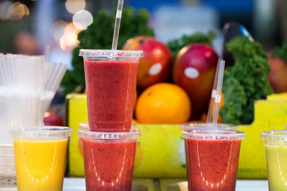 Close up color image depicting freshly made fruit juices and smoothies on display in a row